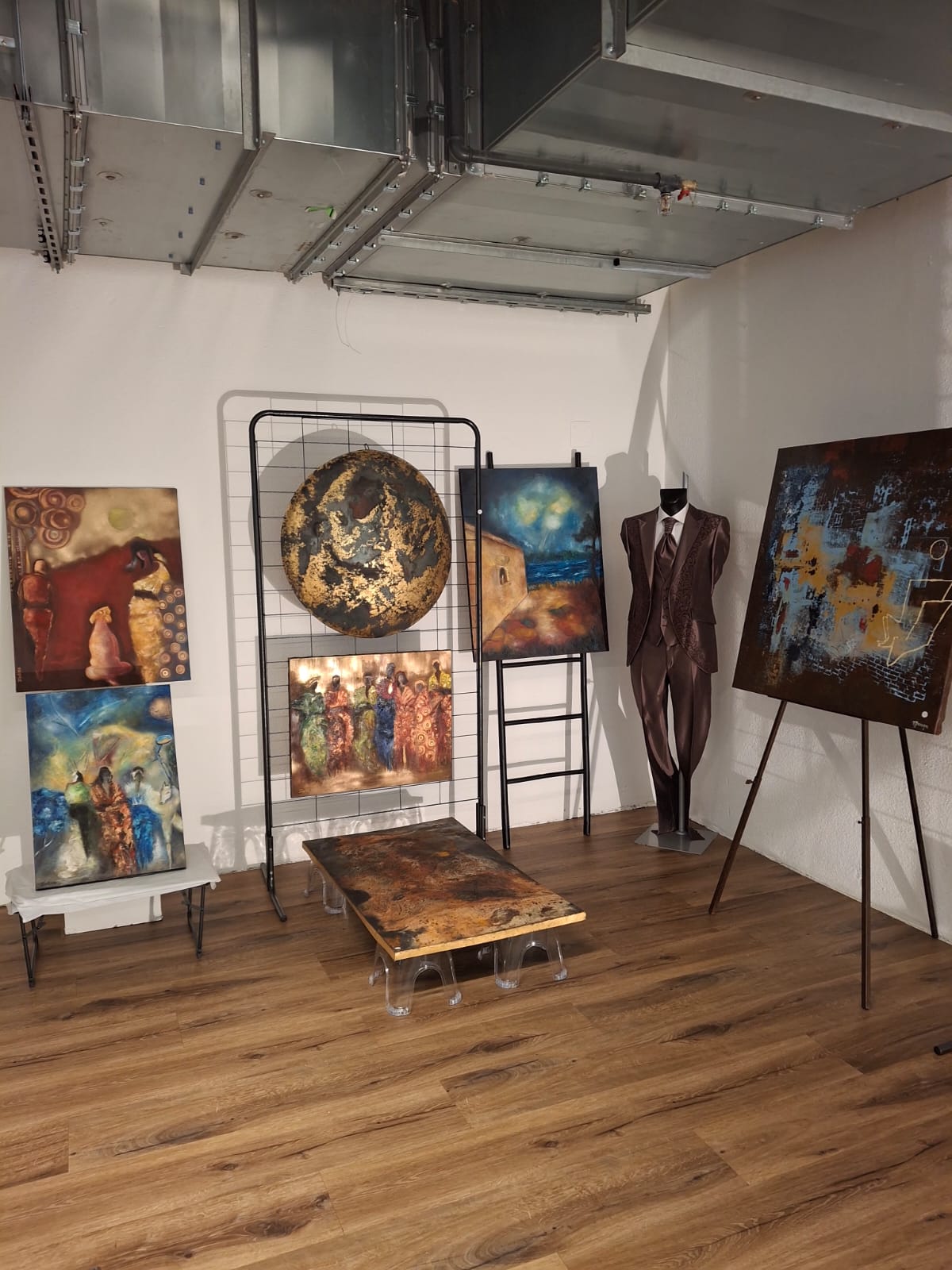 Salle d'exposition avec œuvres et chevalets chez Ros'Art & Culture